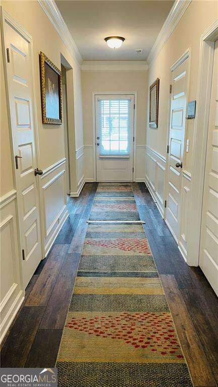 doorway to outside featuring ornamental molding and dark hardwood / wood-style floors