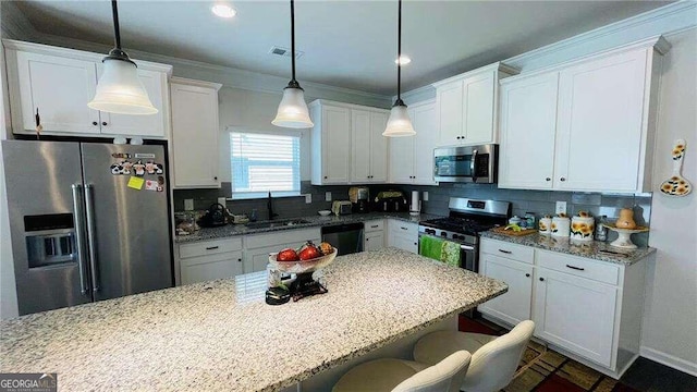 kitchen featuring sink, white cabinetry, stainless steel appliances, decorative light fixtures, and light stone countertops