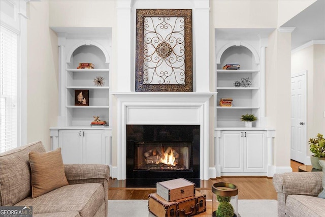 living room featuring built in features and light wood-type flooring