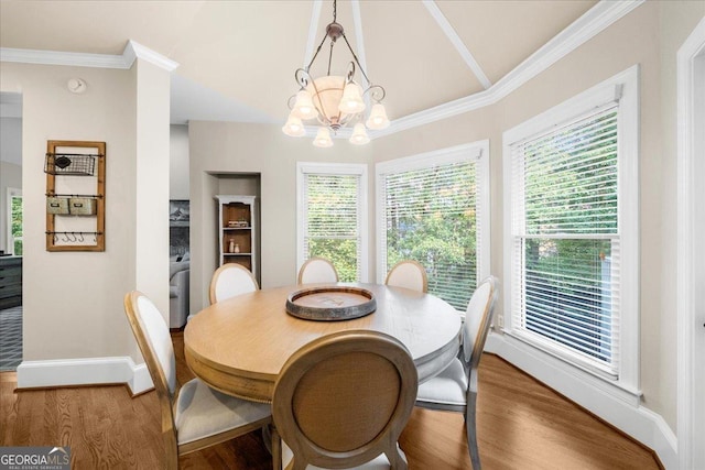 dining area with hardwood / wood-style flooring, a notable chandelier, and ornamental molding