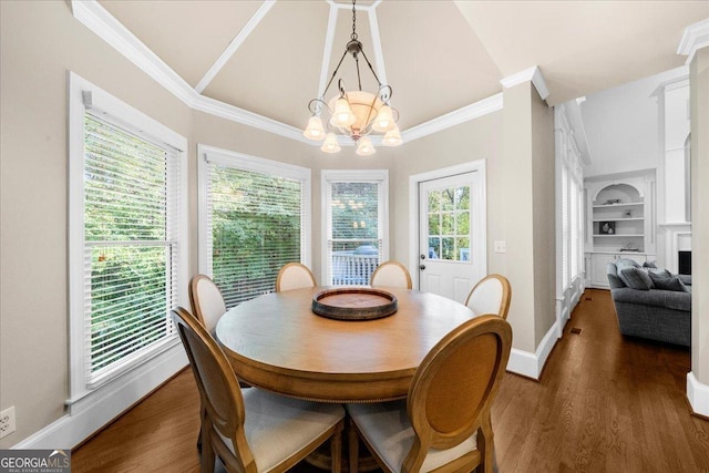 dining area with built in shelves, crown molding, dark hardwood / wood-style floors, and a notable chandelier