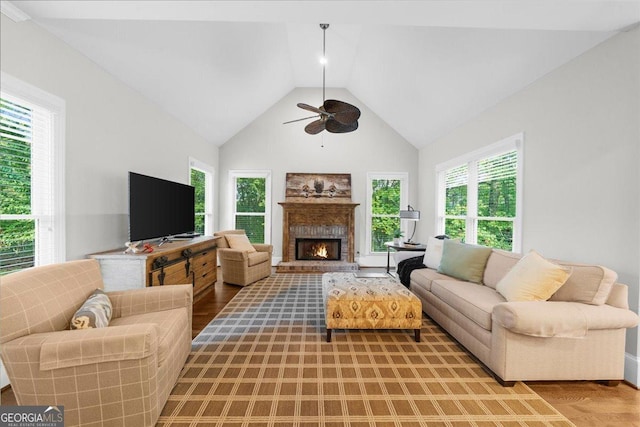 living room with hardwood / wood-style flooring, ceiling fan, and vaulted ceiling