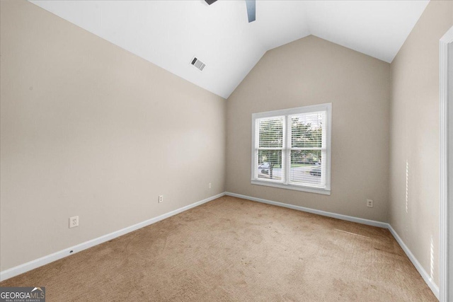 carpeted empty room with ceiling fan and lofted ceiling