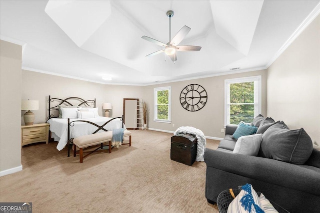 carpeted bedroom featuring ceiling fan, a raised ceiling, crown molding, and multiple windows