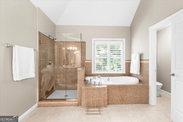 bathroom with tile patterned flooring, shower with separate bathtub, vaulted ceiling, and toilet