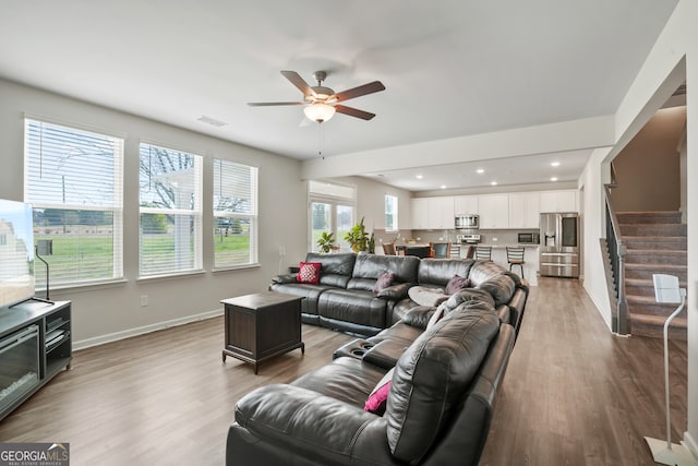 living room featuring light wood-type flooring and ceiling fan