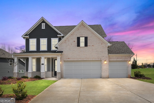 view of front of property with a yard, a garage, and covered porch