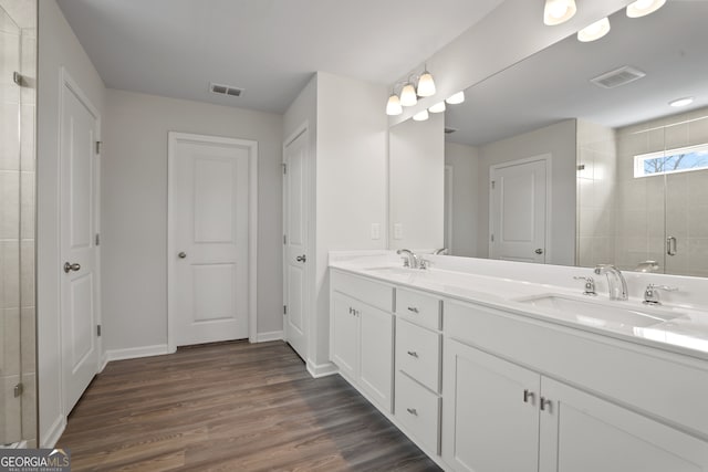 bathroom featuring vanity, hardwood / wood-style floors, and a shower with door