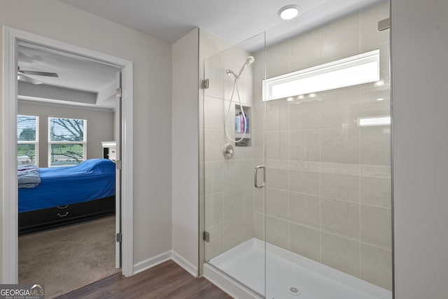 bathroom with wood-type flooring, ceiling fan, and a shower with shower door