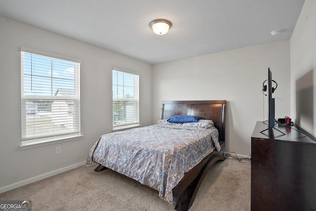 bedroom with light carpet and multiple windows