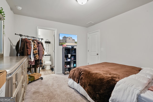 carpeted bedroom featuring ensuite bathroom