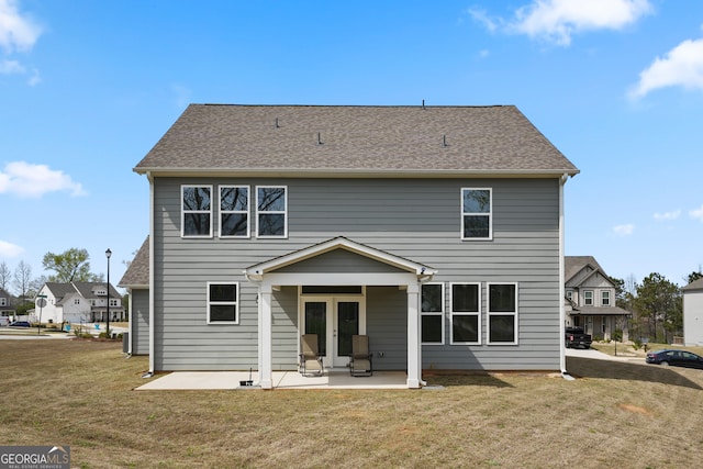 rear view of property with a lawn and a patio