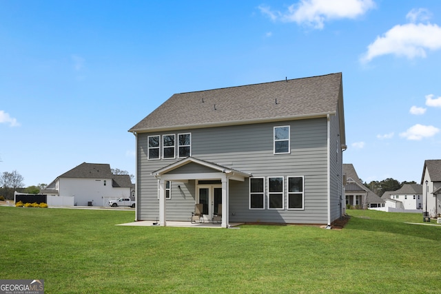 back of property with a lawn and a patio