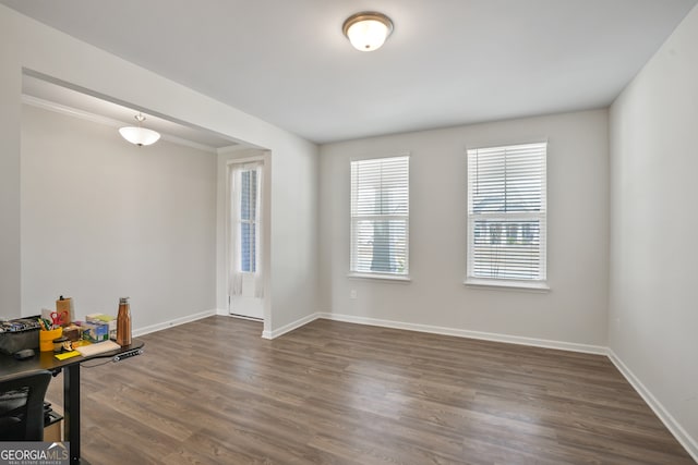 spare room featuring ornamental molding and dark wood-type flooring