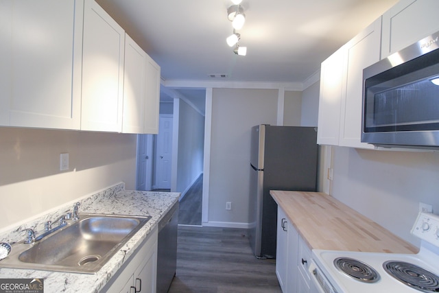 kitchen with crown molding, dark hardwood / wood-style flooring, white cabinetry, and stainless steel appliances