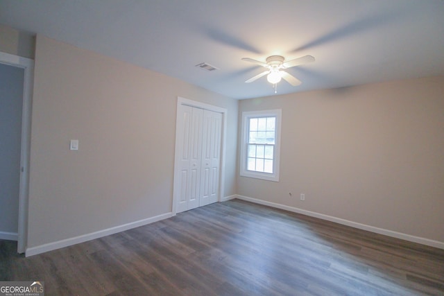 unfurnished bedroom featuring ceiling fan and dark wood-type flooring