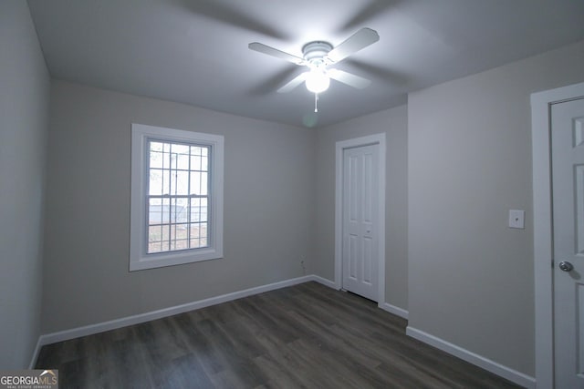 unfurnished bedroom with a closet, ceiling fan, and dark wood-type flooring