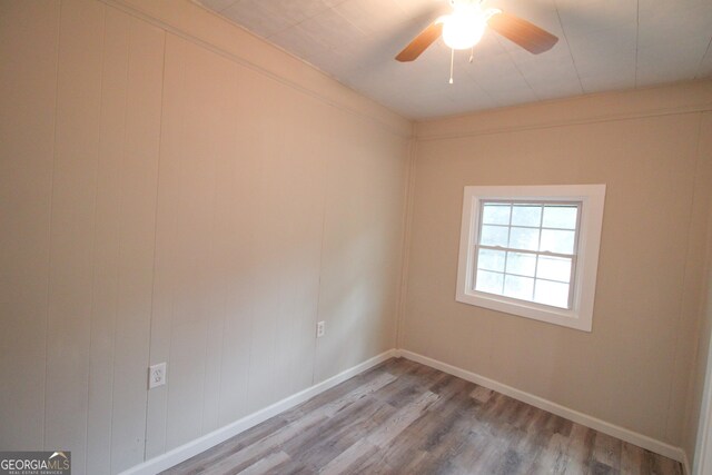 empty room with hardwood / wood-style floors and ceiling fan