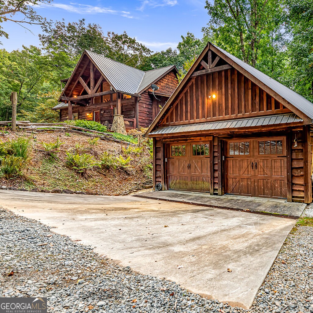 view of front of home with a garage and an outbuilding