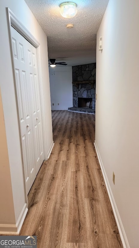 hall with a textured ceiling and hardwood / wood-style floors