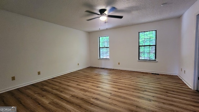 empty room with ceiling fan, a textured ceiling, and hardwood / wood-style floors