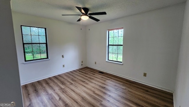 unfurnished room featuring light wood-type flooring, ceiling fan, and a textured ceiling