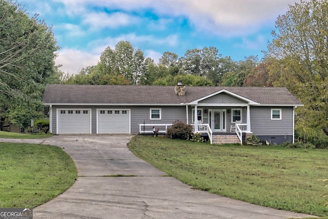 ranch-style home featuring a garage, covered porch, and a front yard