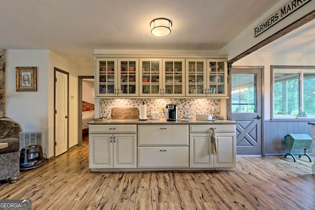 kitchen featuring white cabinets, light wood-type flooring, and decorative backsplash