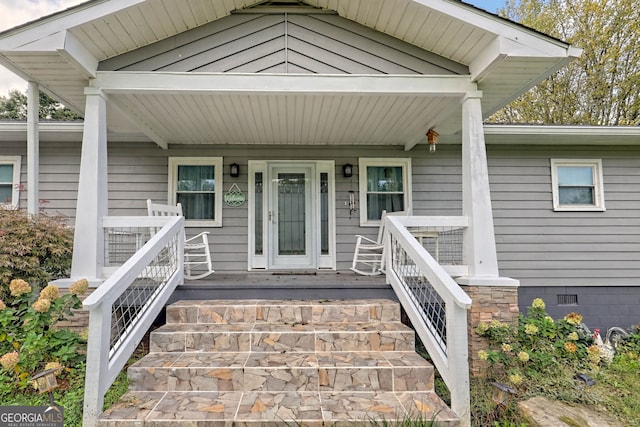 view of exterior entry with a porch