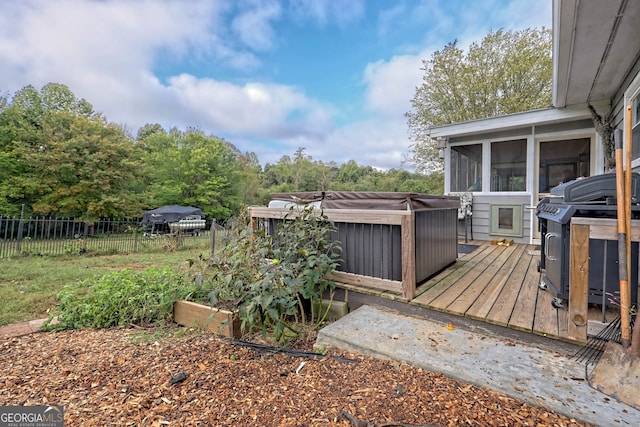 wooden deck with a sunroom, a hot tub, and grilling area