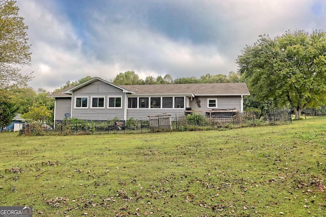 view of front of home featuring a sunroom and a front lawn