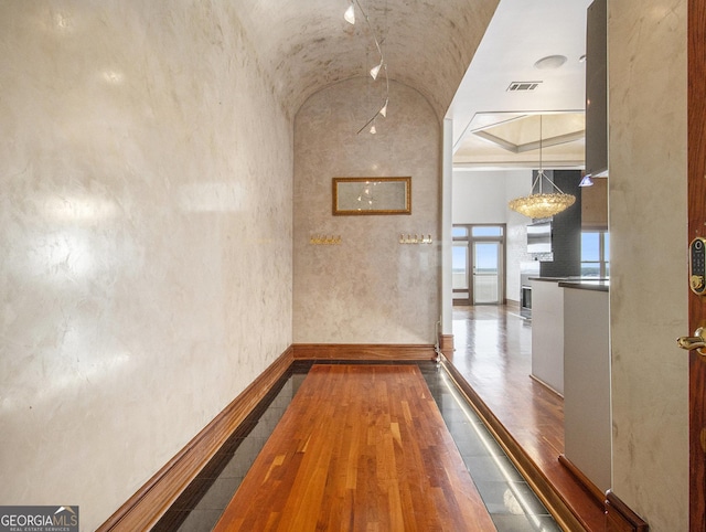 corridor featuring hardwood / wood-style floors and lofted ceiling