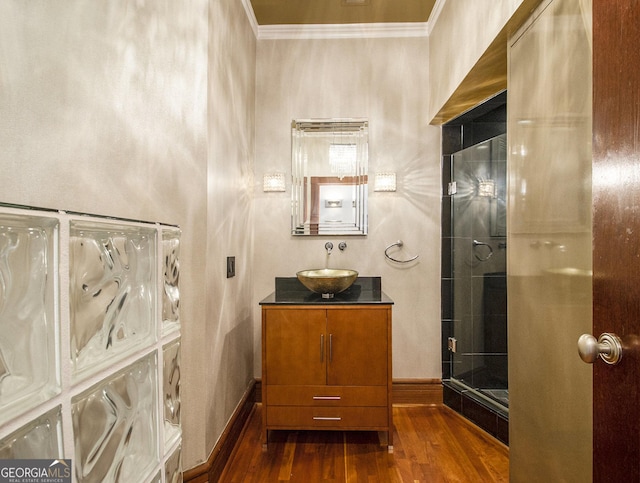 bathroom with vanity, hardwood / wood-style flooring, an enclosed shower, and ornamental molding