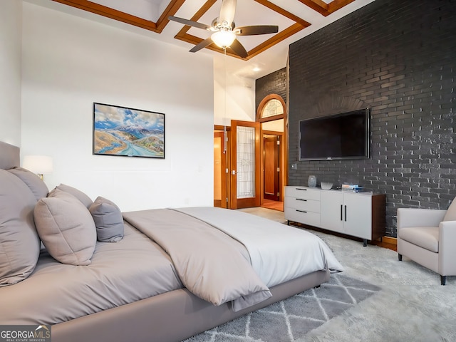 carpeted bedroom featuring ceiling fan and brick wall