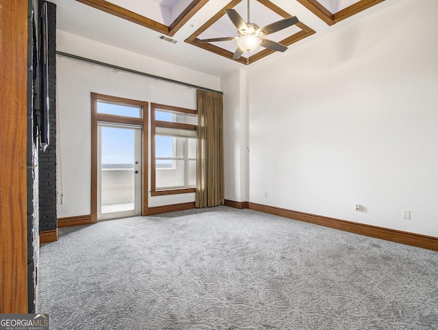 spare room with carpet, ceiling fan, beamed ceiling, and coffered ceiling