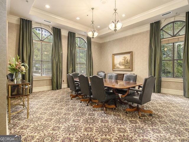 carpeted dining area featuring a tray ceiling, a wealth of natural light, ornamental molding, and an inviting chandelier