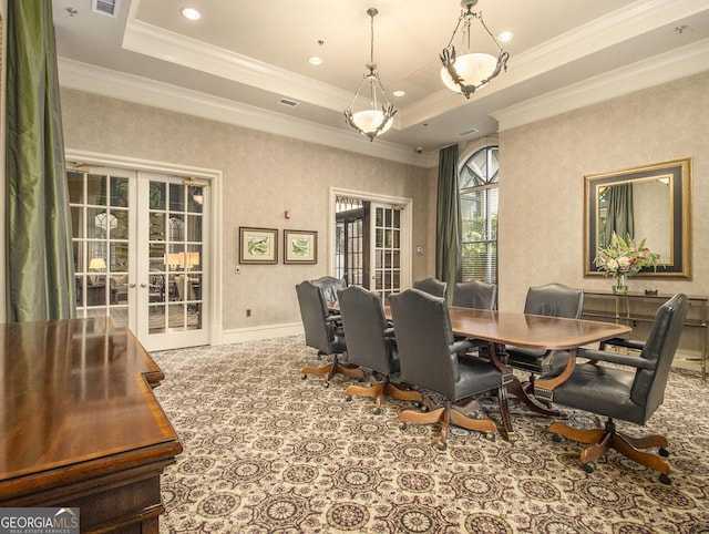 dining area featuring a raised ceiling, crown molding, and french doors