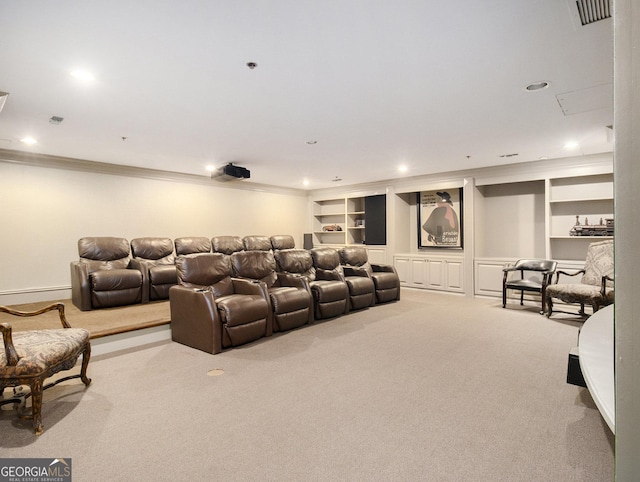 carpeted home theater room featuring built in shelves, crown molding, and a baseboard radiator