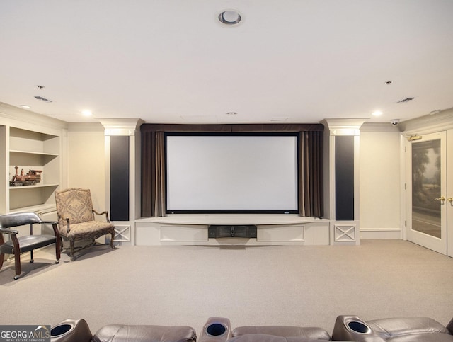 cinema room featuring built in shelves, carpet floors, french doors, and crown molding