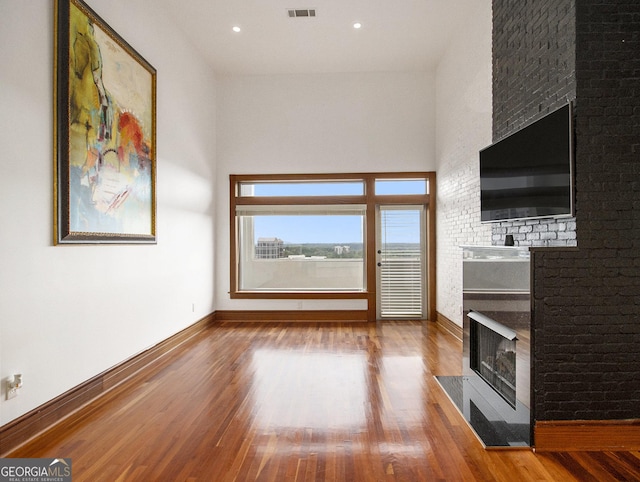 unfurnished living room featuring a fireplace and hardwood / wood-style flooring