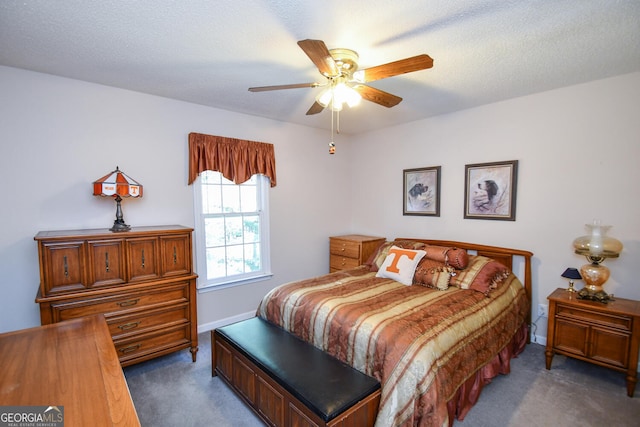 carpeted bedroom with ceiling fan and a textured ceiling