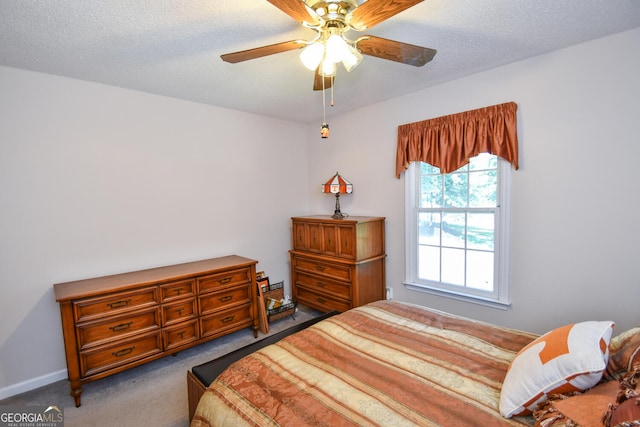 carpeted bedroom with a textured ceiling and ceiling fan