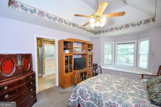 bedroom featuring a raised ceiling, ceiling fan, and light colored carpet