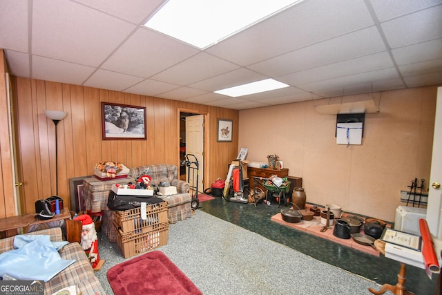 basement with a drop ceiling and wood walls