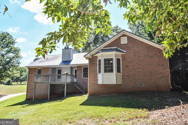 view of front of home featuring a front lawn and a wooden deck