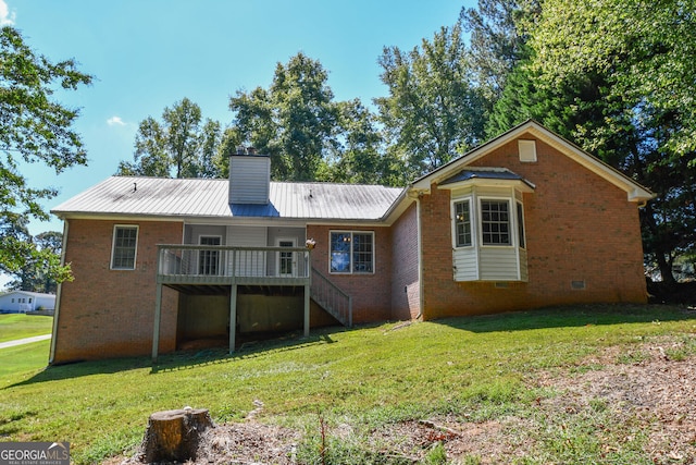 back of property with a deck and a lawn