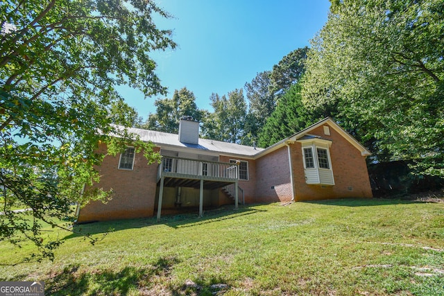 back of property with a lawn and a wooden deck