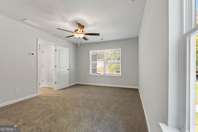 carpeted spare room featuring ceiling fan