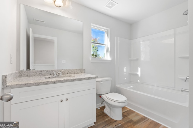 full bathroom featuring hardwood / wood-style flooring, toilet, vanity, and  shower combination