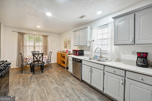 kitchen with gray cabinetry, a textured ceiling, black appliances, hardwood / wood-style floors, and sink